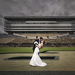  A romantic kiss between the bride and groom in front of a stadium, highlighting their joyous union on this memorable occasion.